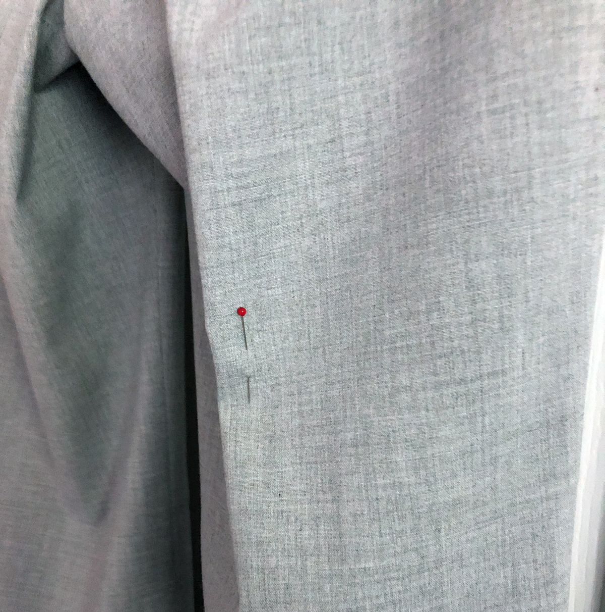Close-up of pin in gray women's pants