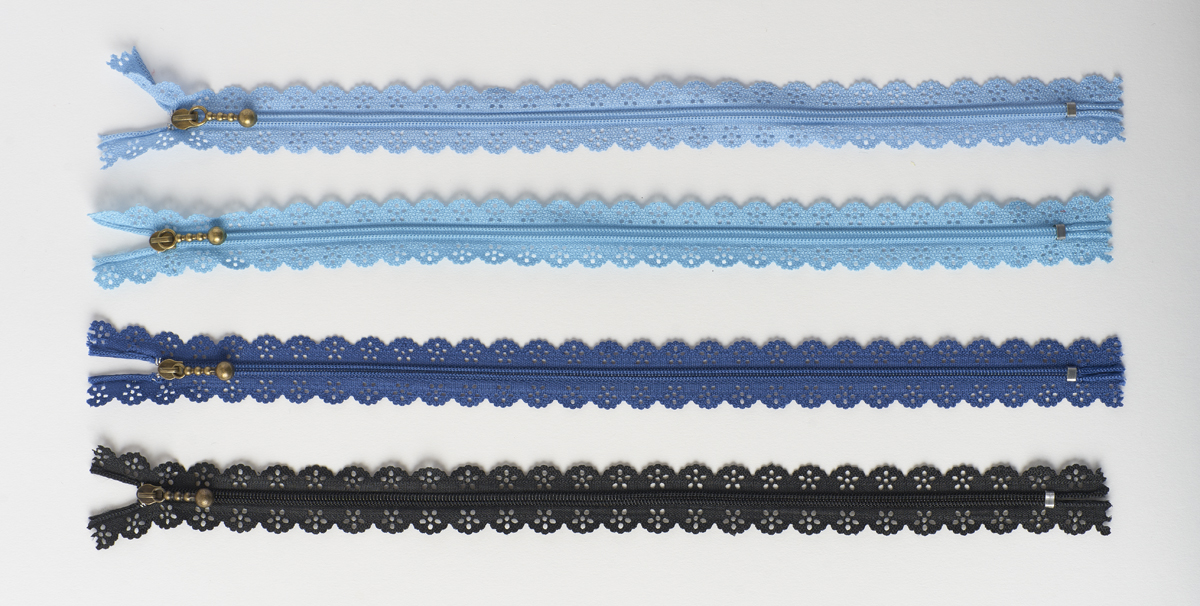 Line-up of zippers with die-cut tapes that give them a lacy look