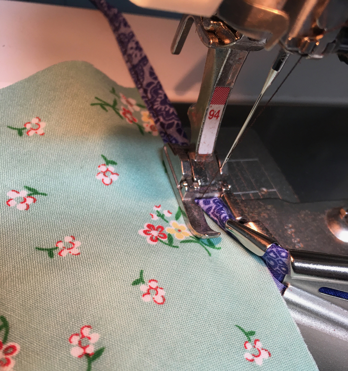 Sewing machine binding foot at work binding a face mask