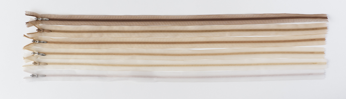 Lightweight zippers lined up in a range of skin tones that can be used in sheer garments