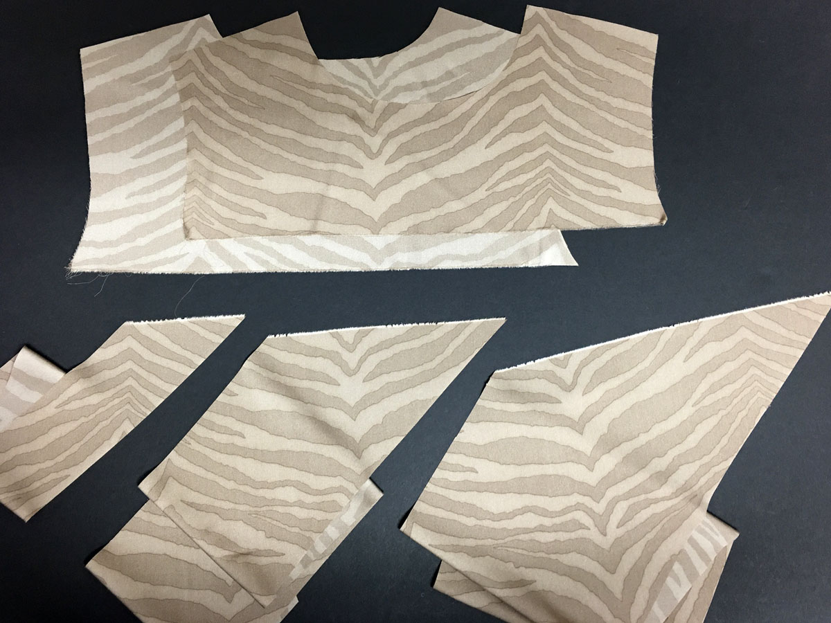 Partial bodice pieces cut from fashion fabric along with 2-inch, 6-inch, and 9-inch bias strips