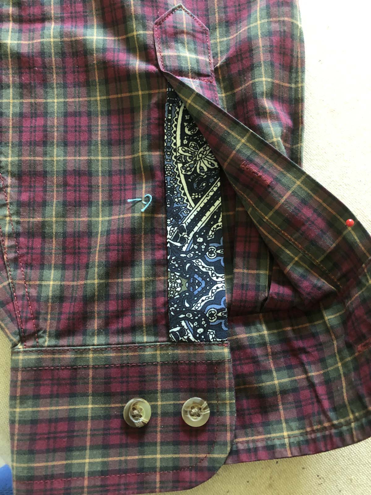Appliqued right sleeve placket on red plaid shirt