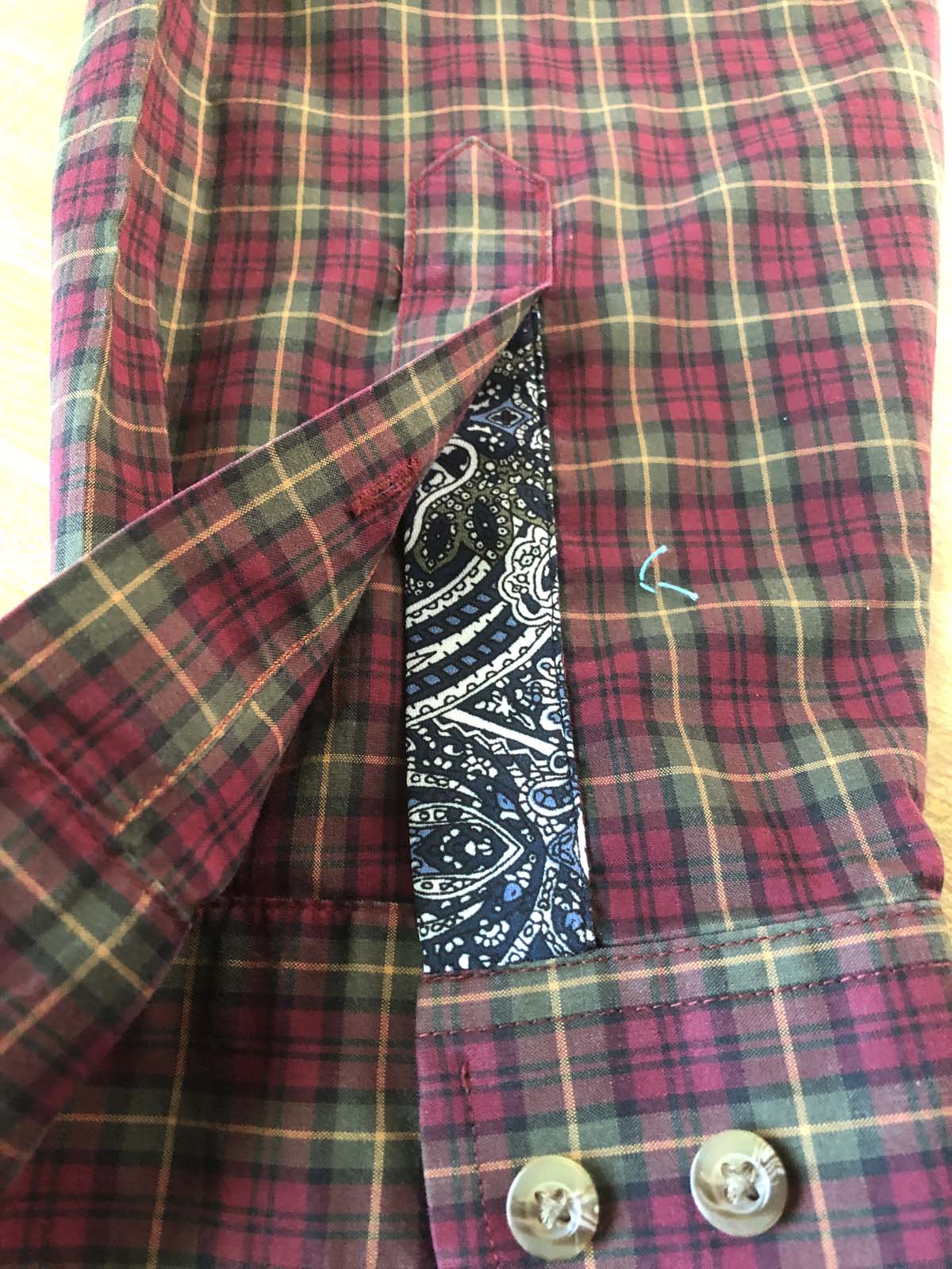 Appliqued left sleeve placket on red plaid shirt