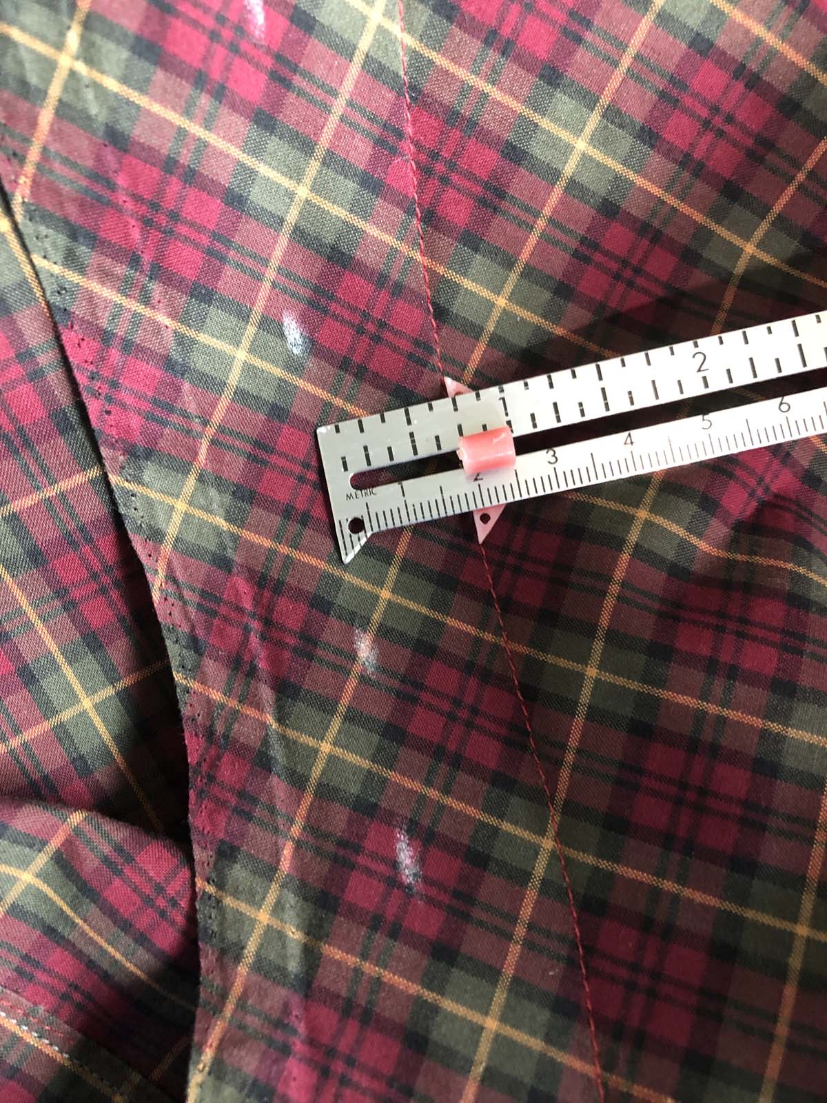 Measuring and marking the excess fabric to be cut away at the armscye edge