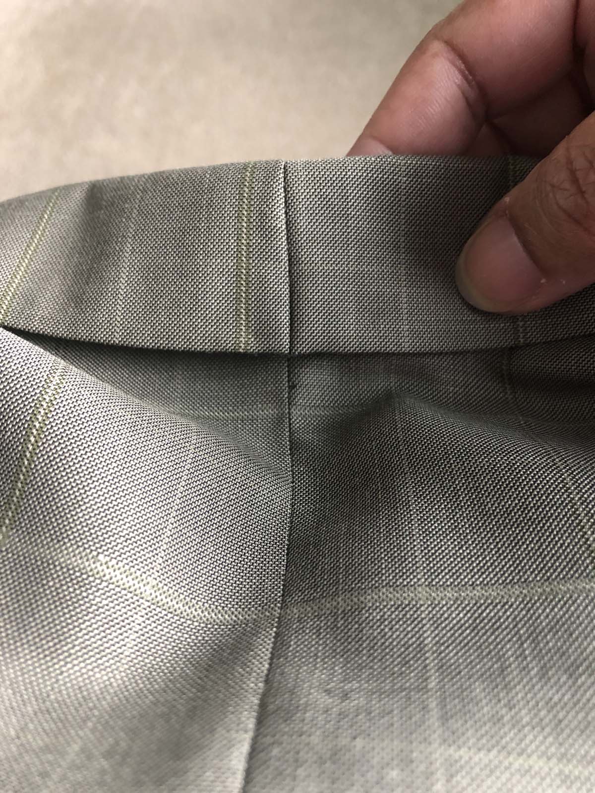 Upper collar of the men's suit jacket is taken in, shown from the right side