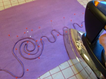 shape the soutache first by steaming in the shape.