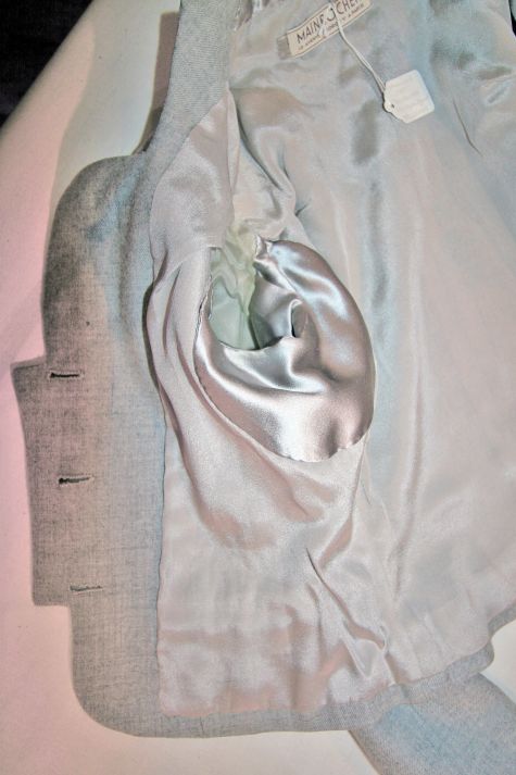 Inside the jacket, a satin facing at the back neck ensures comfort and underarm shields protect the lining.